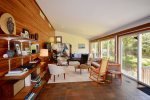 Large living room with flatscreen TV and sliders overlooking yard